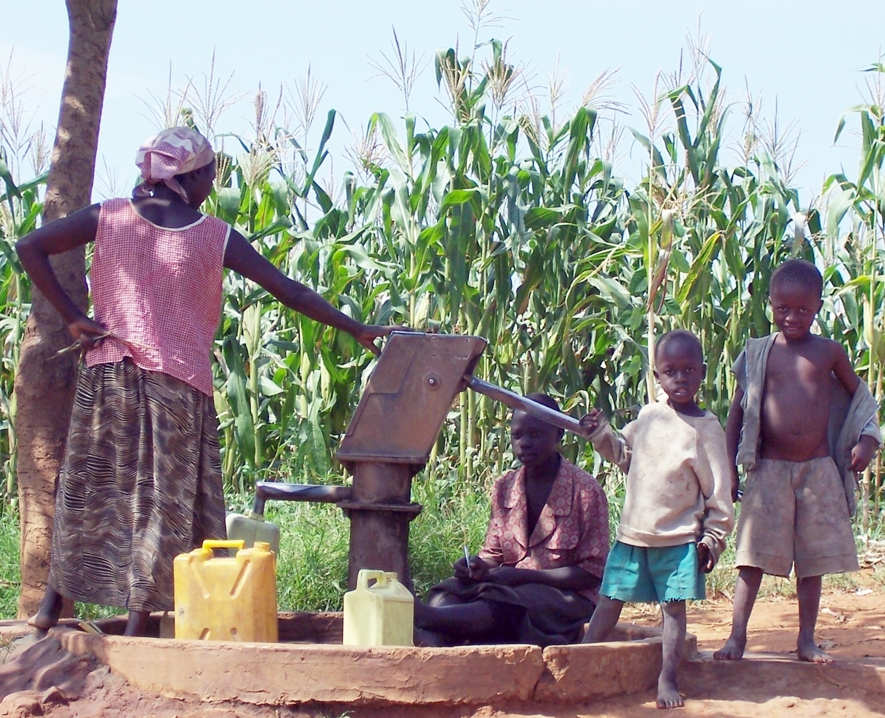 Ugandan family at water well