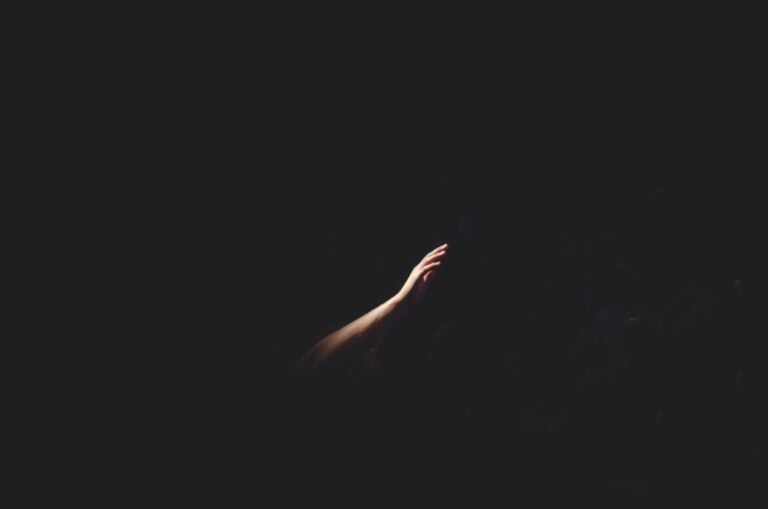 A hand reaching out in the darkness of Advent