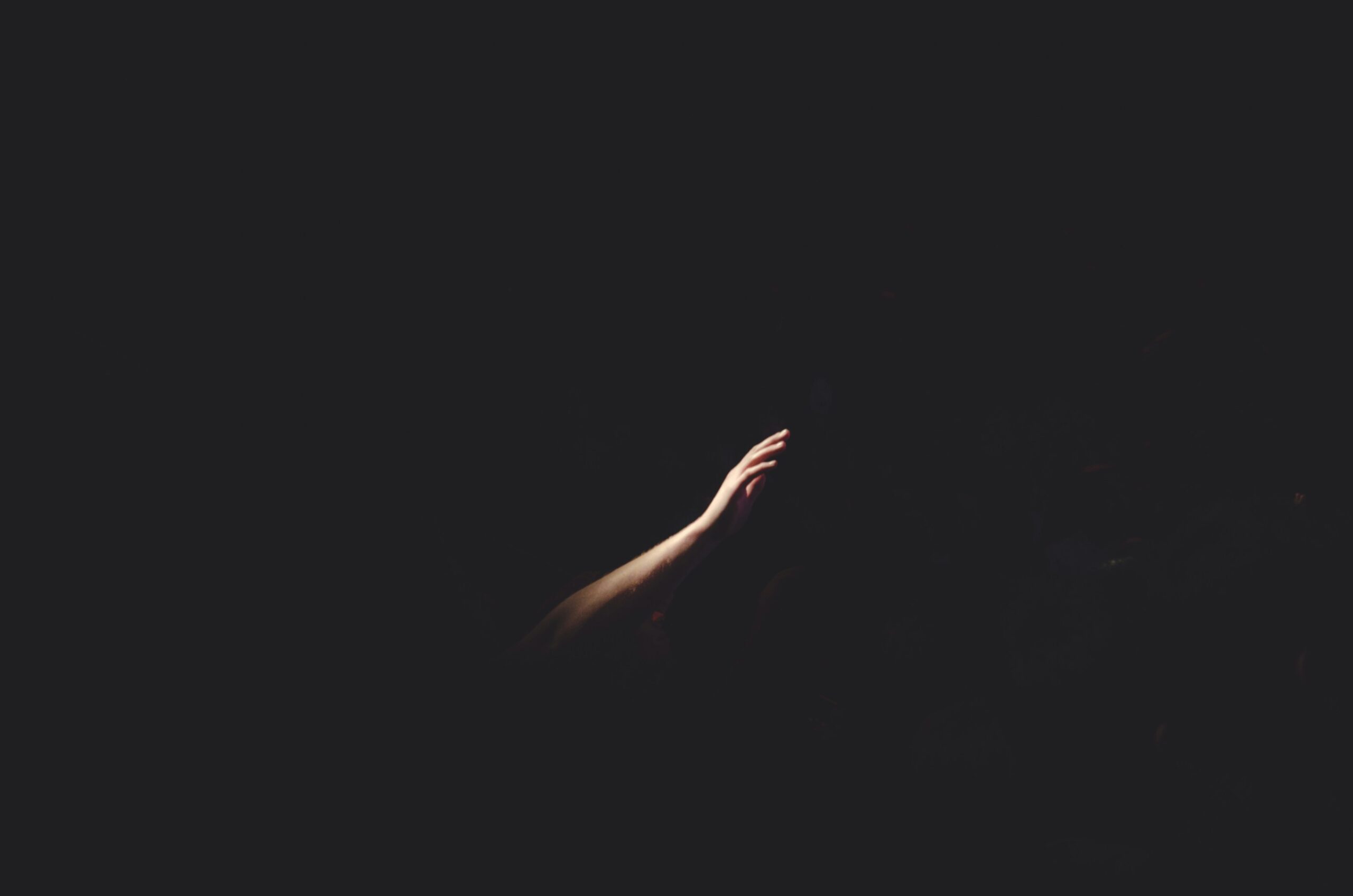 A hand reaching out in the darkness of Advent