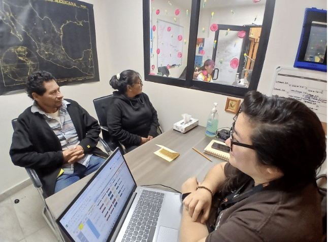 Diana Fajardo, KBI social worker, with parents seeking asylum for their family