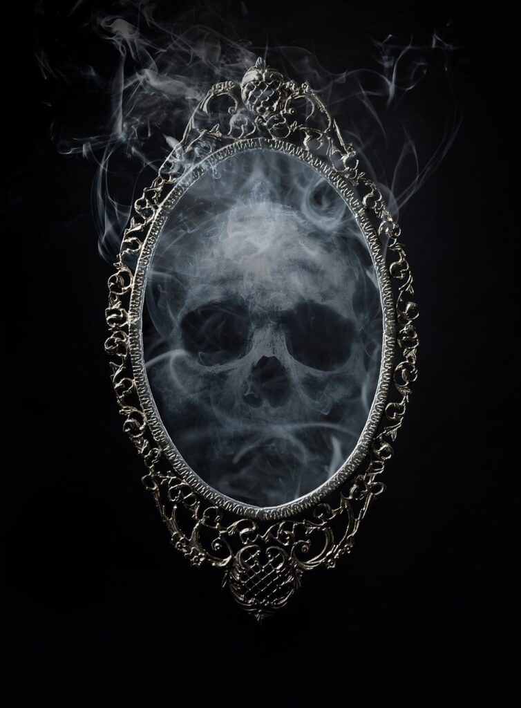 black and white image of a skull made of smoke reflected in an ornate mirror