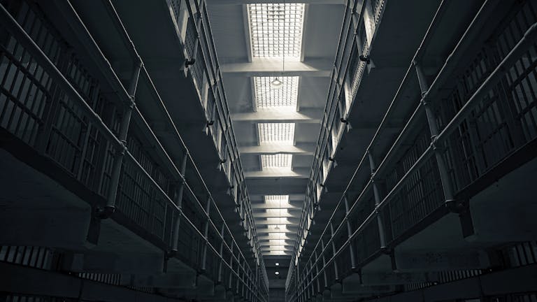 A low-angle view of Alcatraz prison cell block, showcasing steel railings.
