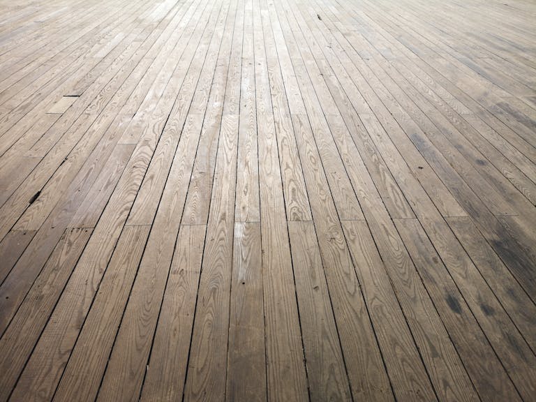 A wide angle view of aged wooden floor planks showing natural texture and grain pattern.