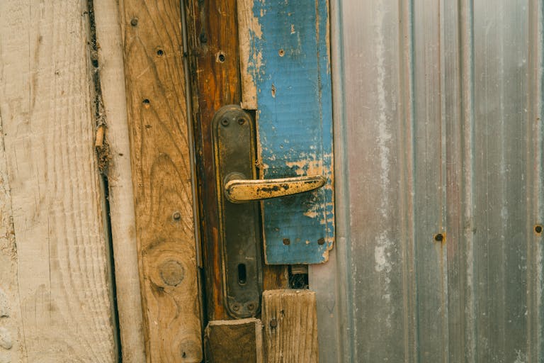 Close-up of a rustic wooden door with a weathered handle and rustic elements.