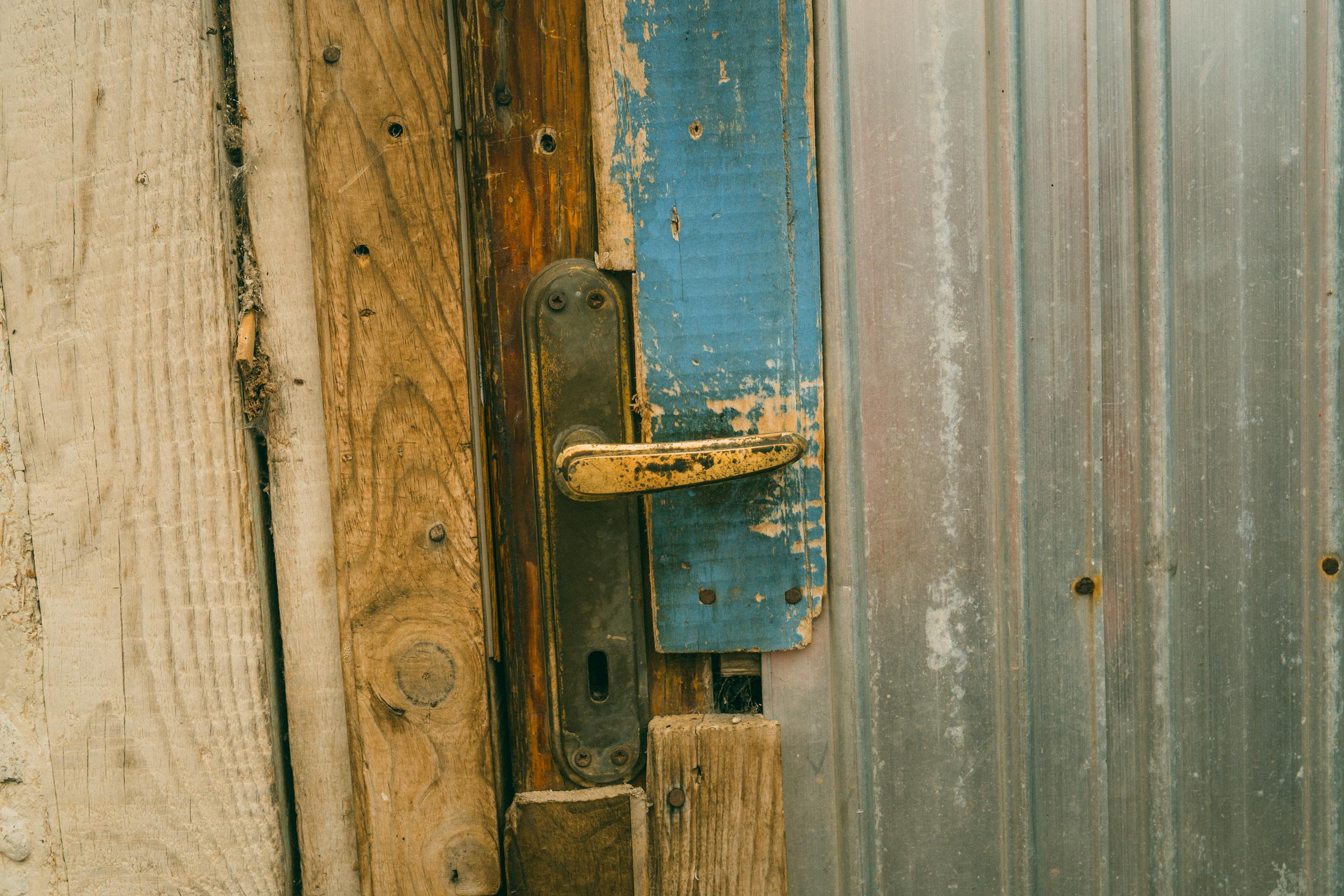 Close-up of a rustic wooden door with a weathered handle and rustic elements.