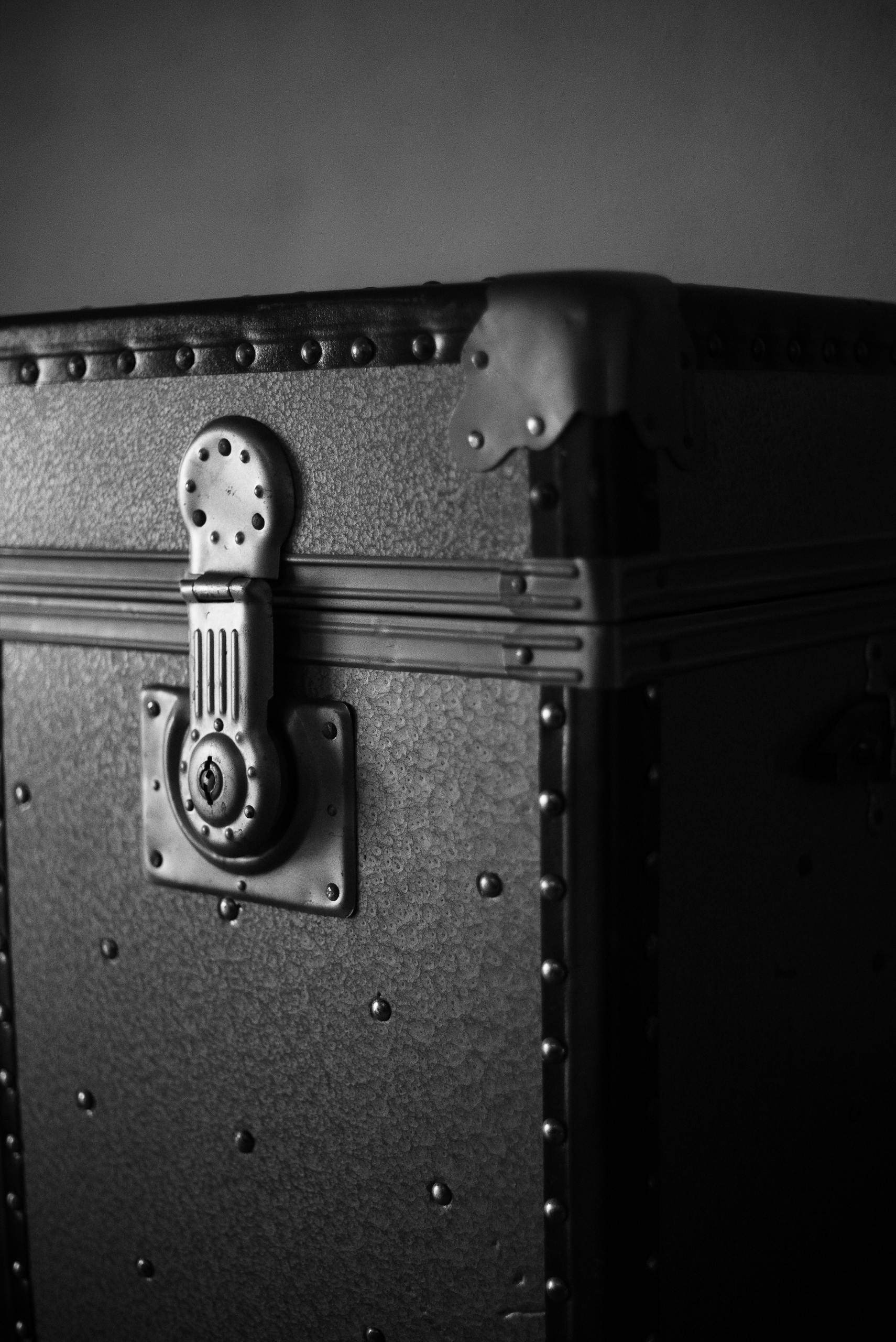 Close-up of a vintage metal chest with a detailed lock, captured in a classic black and white style.