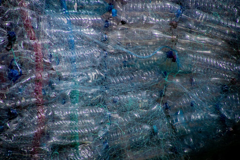 Plastic bottles tightly wrapped in netting for recycling, highlighting waste management.